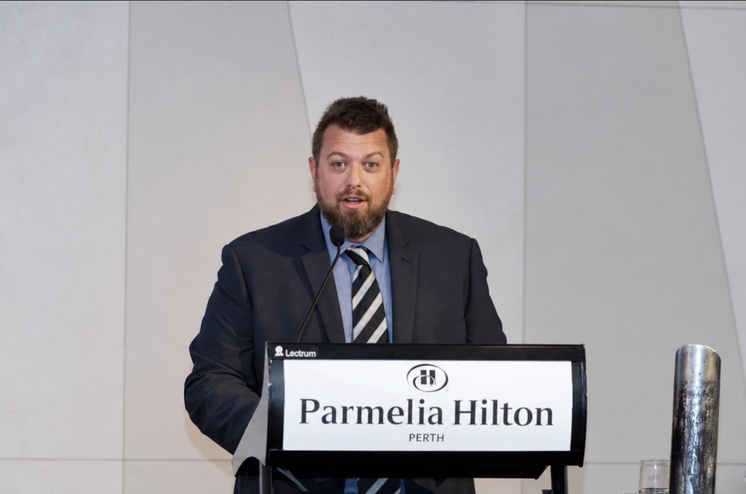 Anthony Pymm presenting from a lectern at a wellbeing event